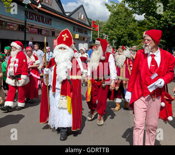 Klampenborg, Dänemark. 20. Juli 2016. Weihnachtsmänner, Elfen und Santas Ehefrauen parade zwischen den Wettbewerben. Seit mehr als 50 Jahren kommen Weihnachtsmänner aus der ganzen Welt dieser 3-Tage-Weltkongress Santa Claus am Bakken, der Vergnügungspark im Hirschpark nördlich von Kopenhagen zu halten. Das Programm an diesem letzten Tag des Kongresses beinhaltet ein Fünfkampf unter Weihnachtsmänner aus mehr als zehn Ländern und Paraden, Unterhaltungen, etc.. Der Weihnachtsmann in der Mitte mit den Bischofsstab und die Mitra-ähnlichen Hut ist aus Deutschland. Bildnachweis: Niels Quist/Alamy Live-Nachrichten Stockfoto