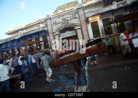 (160722)--ALEXANDRIA (Ägypten), 22. Juli 2016 (Xinhua)--ein Mann trägt Fisch auf dem Fischmarkt in Halaket El-Samak, Alexandria, Ägypten, 21. Juli 2016 verkauft werden. Dieser Fischmarkt hat eine Geschichte von mehr als 200 Jahren. (Xinhua/Ahmed Gomaa) (Nxl) Stockfoto