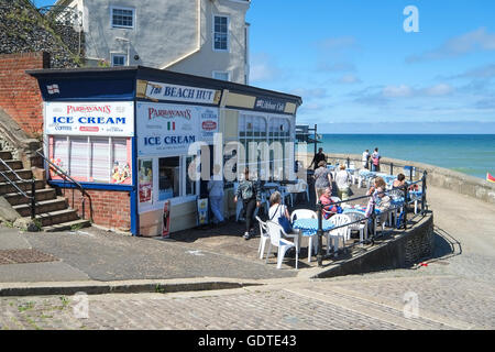 Menschen saßen draußen an einem Cafe mit Blick auf Cromer Strand in Norfolk Stockfoto