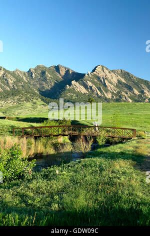 Wanderer gehen über die Brücke, Flatirons im Hintergrund, in Boulder, Colorado, USA Stockfoto