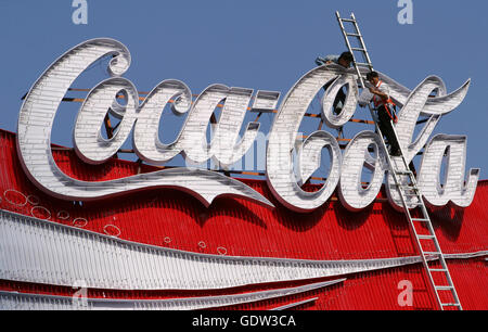 Arbeitnehmer richten Sie ein Coca-Cola Schild auf dem Dach eines Gebäudes Stockfoto