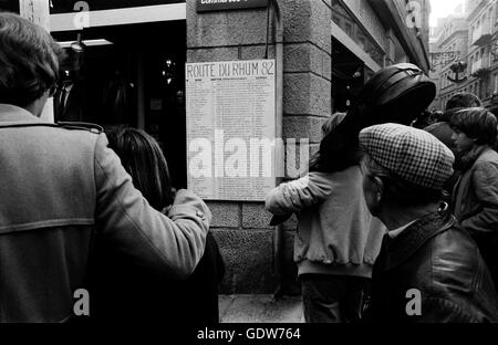 AJAX-NEWS-FOTOS. 1982. ST. MALO. Frankreich. -ROUTE DU RHUM RACE - SCHAULUSTIGE VERSAMMELN SICH, UM AKTUALISIERTE LÄUFER UND REITER RENNLISTE POSTED ON A STREET ECKE DER STADT ZU LESEN.   FOTO: JONATHAN EASTLAND/AJAX REF: 821007 019 Stockfoto