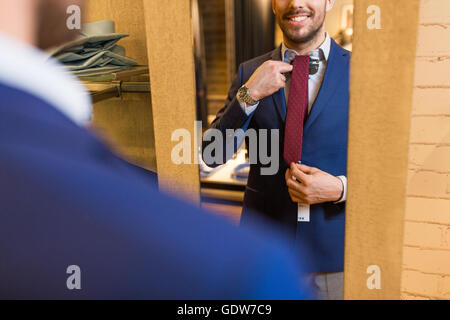 Nahaufnahme des Mannes Krawatte am Spiegel anprobieren Stockfoto