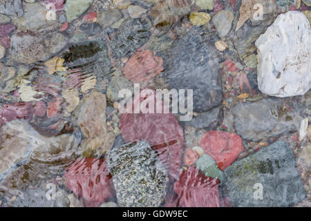 Bunte Felsen unterhalb der Wellen des Creek in Montana Bergen Stockfoto