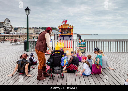 Menschen warten auf den Start eines traditionellen Punch und Judy Show auf Hastings Pier, Hastings, Sussex, UK Stockfoto