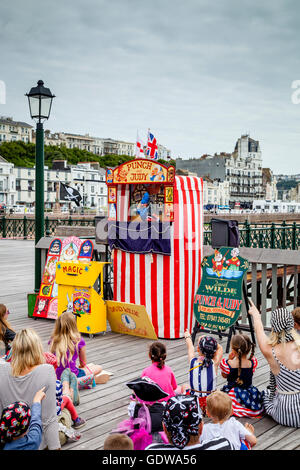 Leute zu beobachten, eine traditionelle Punch und Judy Show am Hastings Pier, Hastings, Sussex, UK Stockfoto