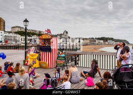 Leute zu beobachten, eine traditionelle Punch und Judy Show am Hastings Pier, Hastings, Sussex, UK Stockfoto