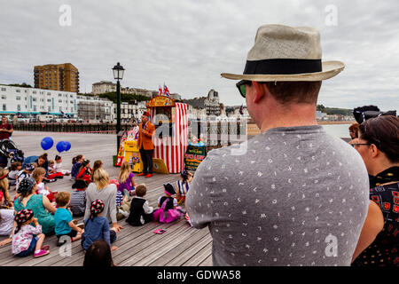 Leute zu beobachten, eine traditionelle Punch und Judy Show am Hastings Pier, Hastings, Sussex, UK Stockfoto