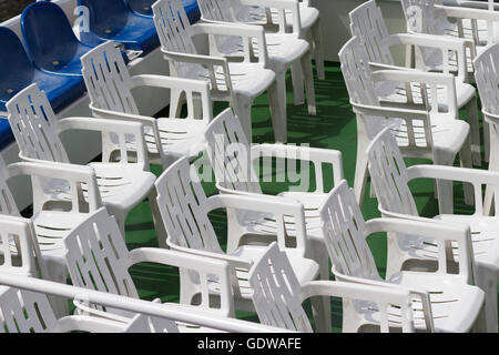 viele leere weiße Plastikstühle in Reihen Stockfoto