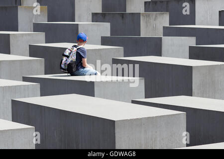 Junge sitzt auf das Denkmal für die ermordeten Juden Europas, auch bekannt als das Holocaust-Mahnmal Stockfoto