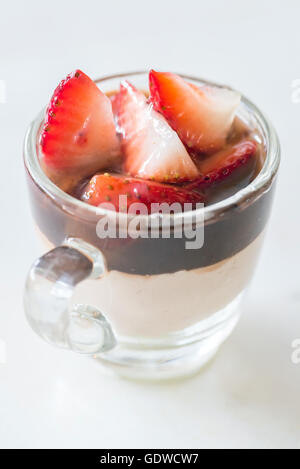 Schokoladenmousse garniert mit Erdbeeren Obst im Glas auf weißem Hintergrund Stockfoto