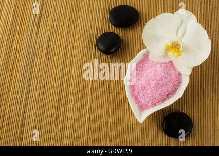 Spa-Konzept mit rosa Meer Salz und Spa Steinen.  Spa-Behandlung-Konzept. Wellness-Stillleben. Stockfoto