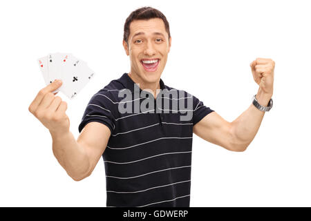 Glücklicher junger Mann vier Asse in der Hand hält und gestikulierte Glück isoliert auf weißem Hintergrund Stockfoto