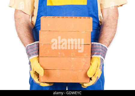 Arbeiter in Arbeitskleidung und Handschuhe hält ein paar Ziegel in seinen Händen. Stockfoto