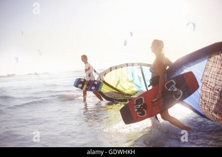 Paare, die in Surf mit Kiteboard equipment Stockfoto