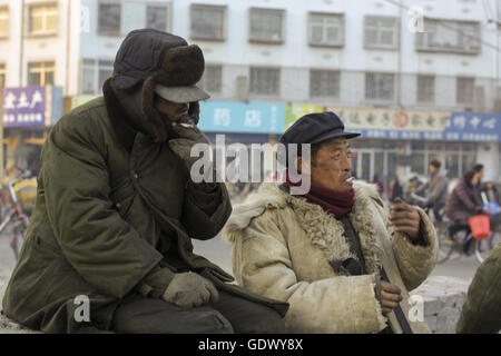 Zwei Arbeiter rauchen Zigaretten in einer Straße Stockfoto
