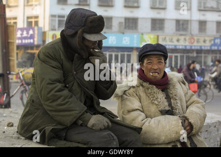 Zwei Arbeiter rauchen Zigaretten in einer Straße Stockfoto