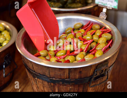 Grüne Oliven mit roten Peri-Peri Chili auf Verkauf in Marktstand, UK Stockfoto