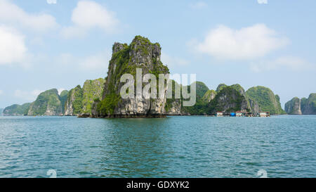 Großen Klippen aus dem Meer mit kleinen schwimmenden Fischerdorf neben Ihnen, im schönen Ha Long Bucht im Norden Vietnams Stockfoto