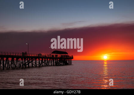 Menschen zu Fuß auf der Henley Beach Mole bei Sonnenuntergang, South Australia. Farbe-toning angewendet Stockfoto