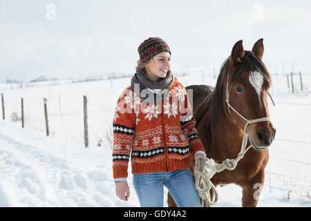 Junge Frau mit Pferd auf dem Bauernhof, Bayern, Deutschland Stockfoto