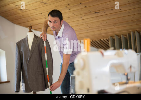 Männliche Schneiderin Messung Jacke auf Schneiderin Modell, Bayern, Deutschland Stockfoto