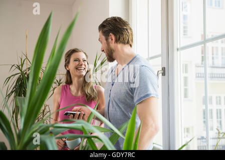 Paar im Wohnzimmer stehen und sahen einander, München, Bayern, Deutschland Stockfoto