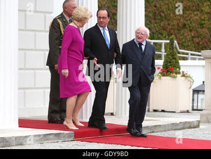 Der französische Präsident Francois Hollande (Mitte) spricht mit Präsident von Irland Michael D Higgins und seine Frau Sabina Higgins verlässt er Aras ein Uachtarain in Dublin. Stockfoto