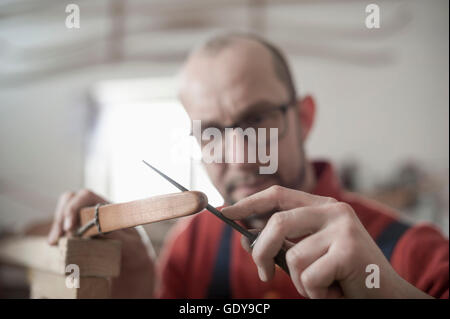 Männliche Bogenmacher Dateien die Tipps eines Bogens in Werkstatt, Bayern, Deutschland Stockfoto