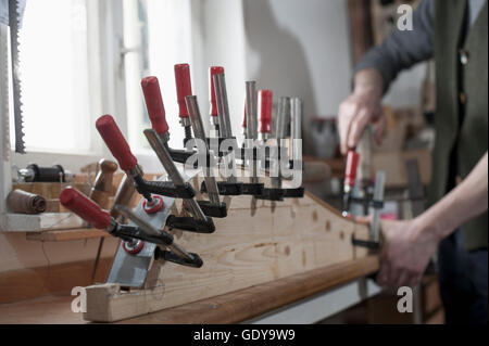 Männliche Bogenmacher Befestigung Holz in Form von Bogen in Werkstatt, Bayern, Deutschland Stockfoto