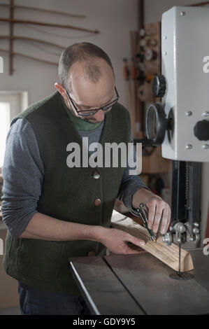 Männliche Bogenmacher markieren auf Holz mit Kompass, Workshop, Bayern, Deutschland Stockfoto