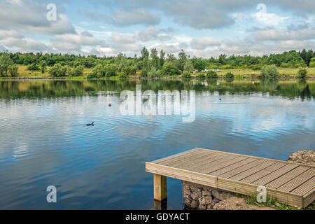 Der See im Parc Bryn Bach in der Nähe von Tredegar in den walisischen Tälern, mit einem Spaziergang. Stockfoto