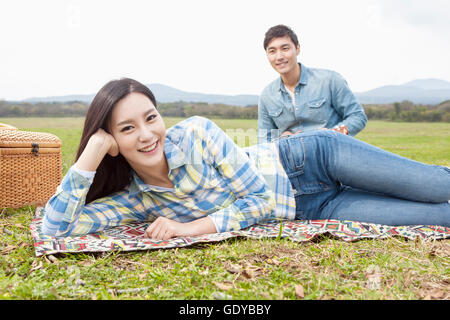 Junge, lächelnde paar mit einem Picknick auf der Wiese Stockfoto