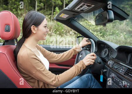 Seite Ansicht Porträt des jungen lächelnde Frau Autofahren Stockfoto