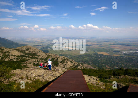 Verzweifelte Frauen sitzen am Rand einer Klippe und Blick aus der Vogelperspektive auf Tal. Stockfoto