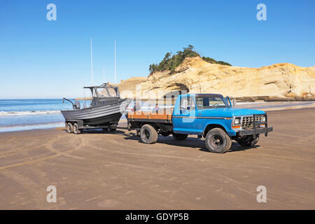 Eine Fischerei Dory ist vom Meer von seinem Besitzer am Strand von Cape Kiwanda in der Nähe von Pacific City abgerufen, Oregon.Cape Kiwanda ist eine Stockfoto