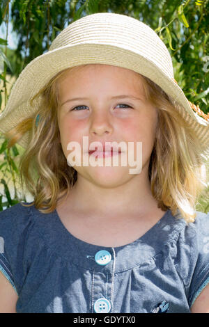 Kleines Mädchen mit Strohhut Stockfoto