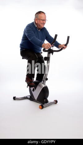 ÄLTERE Mann ON AN Übung BIKE einen älteren Mann ein Ergometer ausprobieren Stockfoto