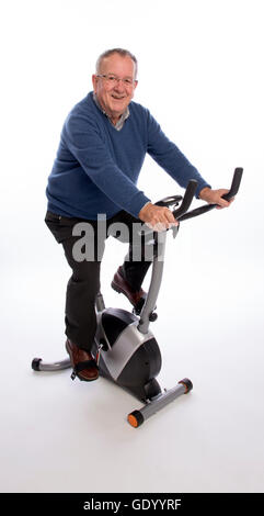 ÄLTERE Mann ON AN Übung BIKE einen älteren Mann ein Ergometer ausprobieren Stockfoto