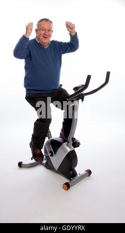 ÄLTERE Mann ON AN Übung BIKE einen älteren Mann ein Ergometer ausprobieren Stockfoto