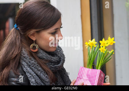 Junge Frau kaufen gelbe Narzisse Blumen in den Blumenladen, Freiburg Im Breisgau, Baden-Württemberg, Deutschland Stockfoto