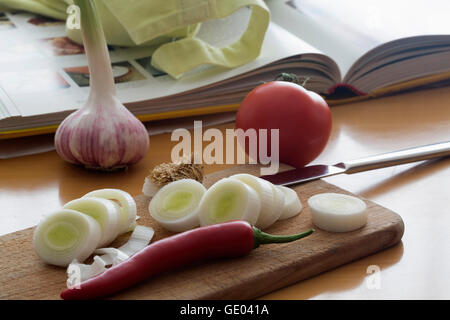 Scheiben von Fenchel mit Chili und Kochbuch auf dem Tisch Stockfoto