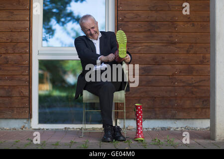 Leitenden Geschäftsmann Anzug und setzen Wellington Boot, Freiburg Im Breisgau, Baden-Württemberg, Deutschland Stockfoto