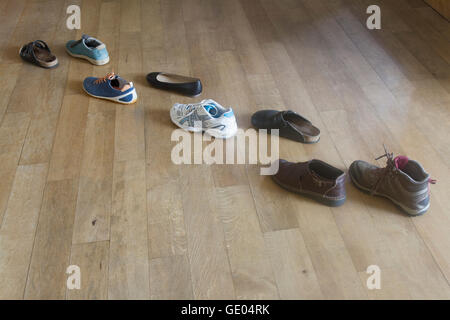 Vielzahl von Schuhen auf Holzboden Stockfoto