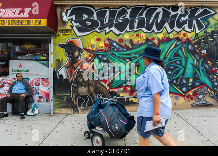 New York City, NY, USA, Amerikaner in Brooklyn, Bushwick Nachbarschaft, weibliche Mailperson, Walking Store Front Street Art, Gentrifizierung der Stadtgebiete in den USA; öffentliche Kunst New york City bunt, Grafitti brooklyn Stockfoto