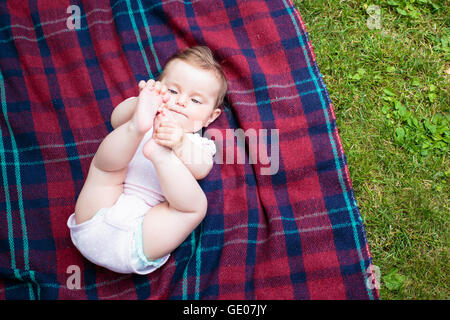 Baby auf Decke im Garten liegen Stockfoto