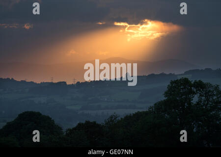 Sonnenstrahl über Cotswold Landschaft mit Malvern Hills in Ferne Stockfoto