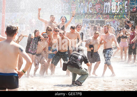 Fotografen unter Bild von Menschen spielen im Schlamm während 21. Woodstock-Festival Stockfoto