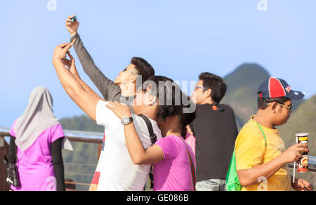 Langkawi, Malaysia - 13. Januar 2015: Touristen fotografieren Selfie oben auf Langkawi Cable Car Aussichtspunkt bei Sonnenuntergang. Stockfoto