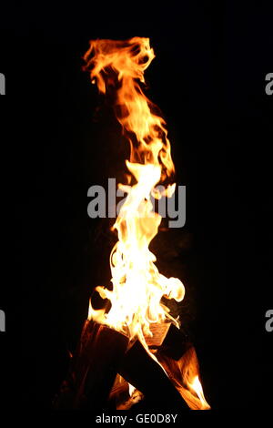 Flamme auf der Brennholz auf dem dunklen Hintergrund Stockfoto